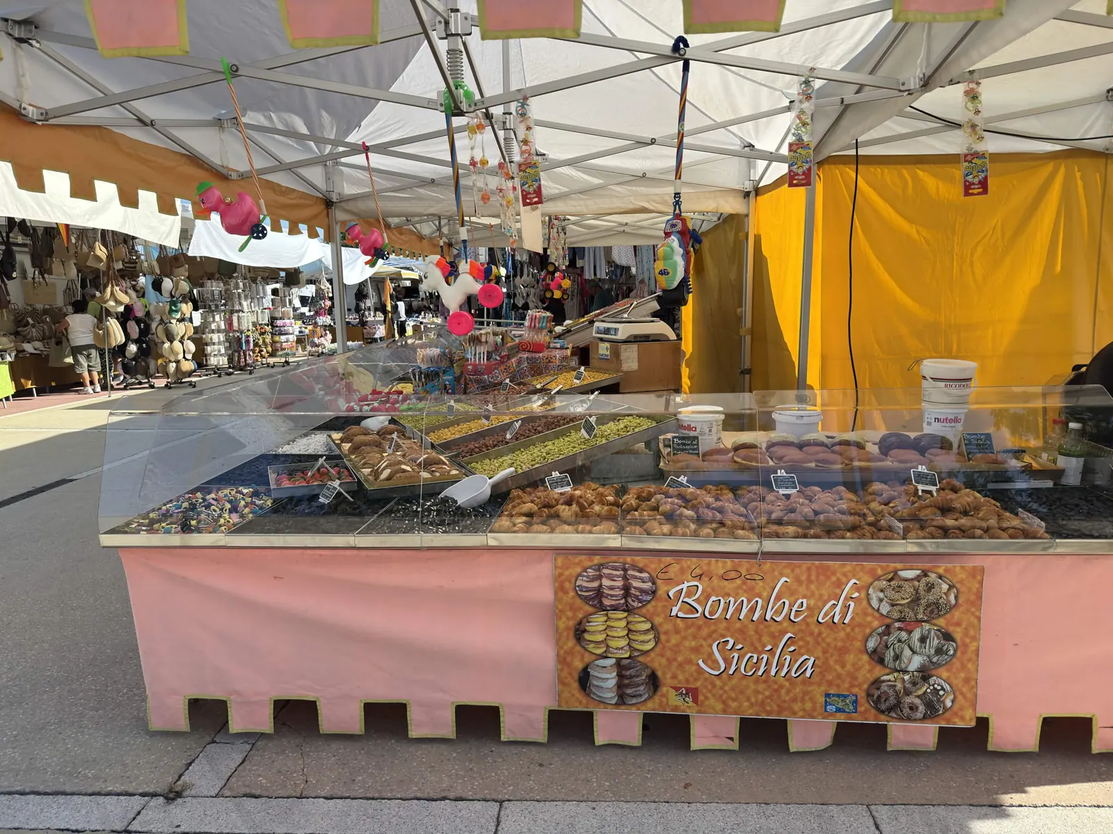 Il banco Il Siciliano al mercato: vetrine di caramelle, liquirizie, cannoli e bombe di Sicilia